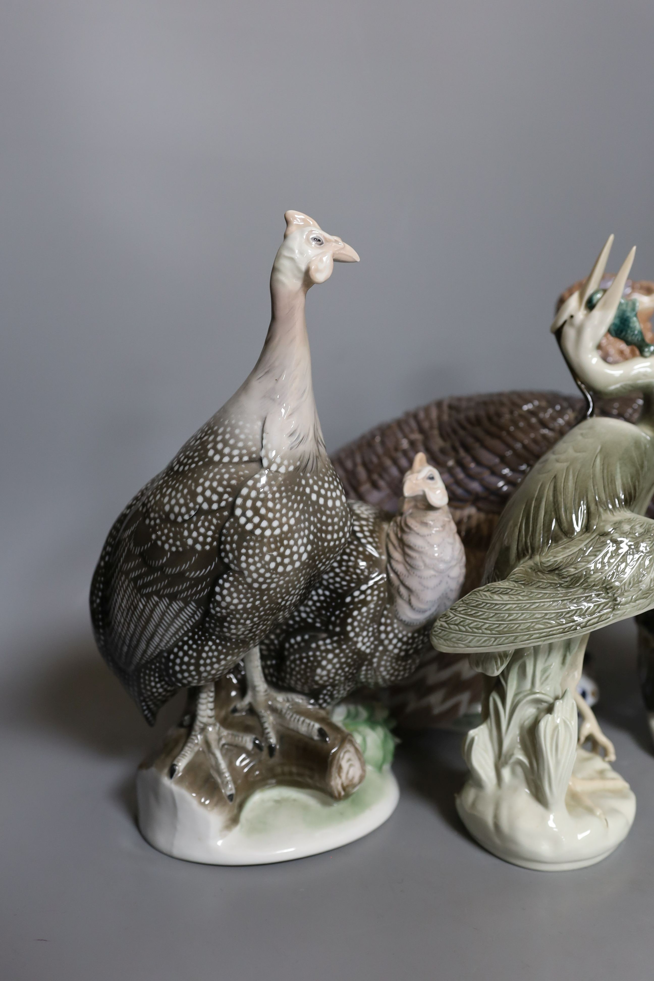 A Rosenthal porcelain model of two guinea fowl, impressed model number 205, a Bing & Grondahl limited edition model of a turkey, no.31 of 750, model 2426 or 2727, a Royal Dux porcelain model a heron and a Karl Ens group